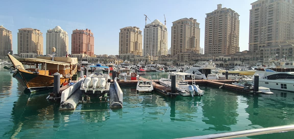Pearl Qatar marina with dhow and luxury yachts